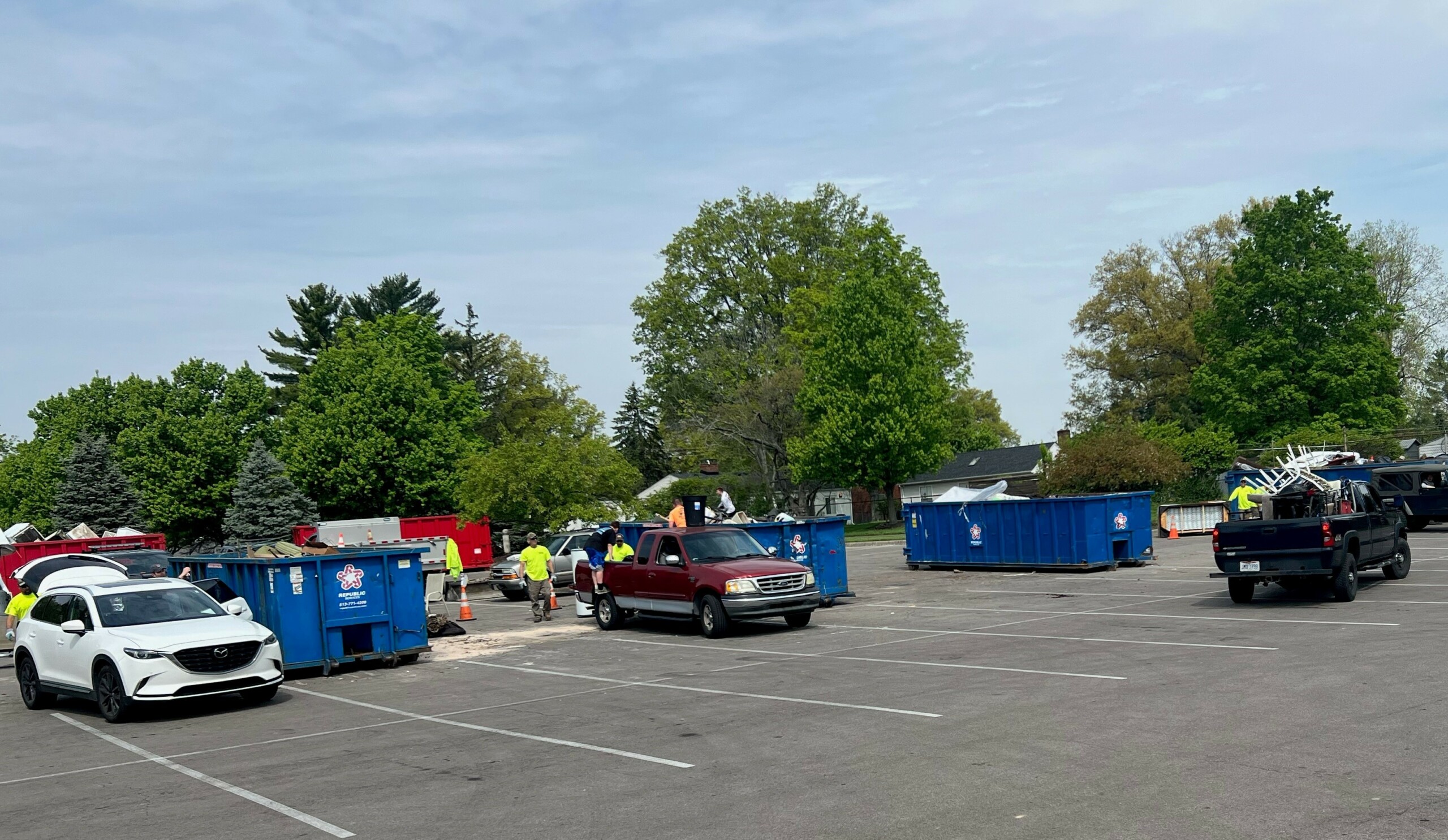 dumpsters and cars unloading at trash bash