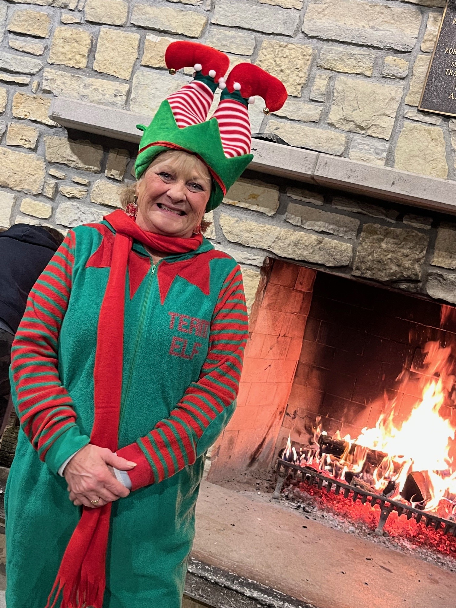 woman dressed in elf costume in front of fireplace