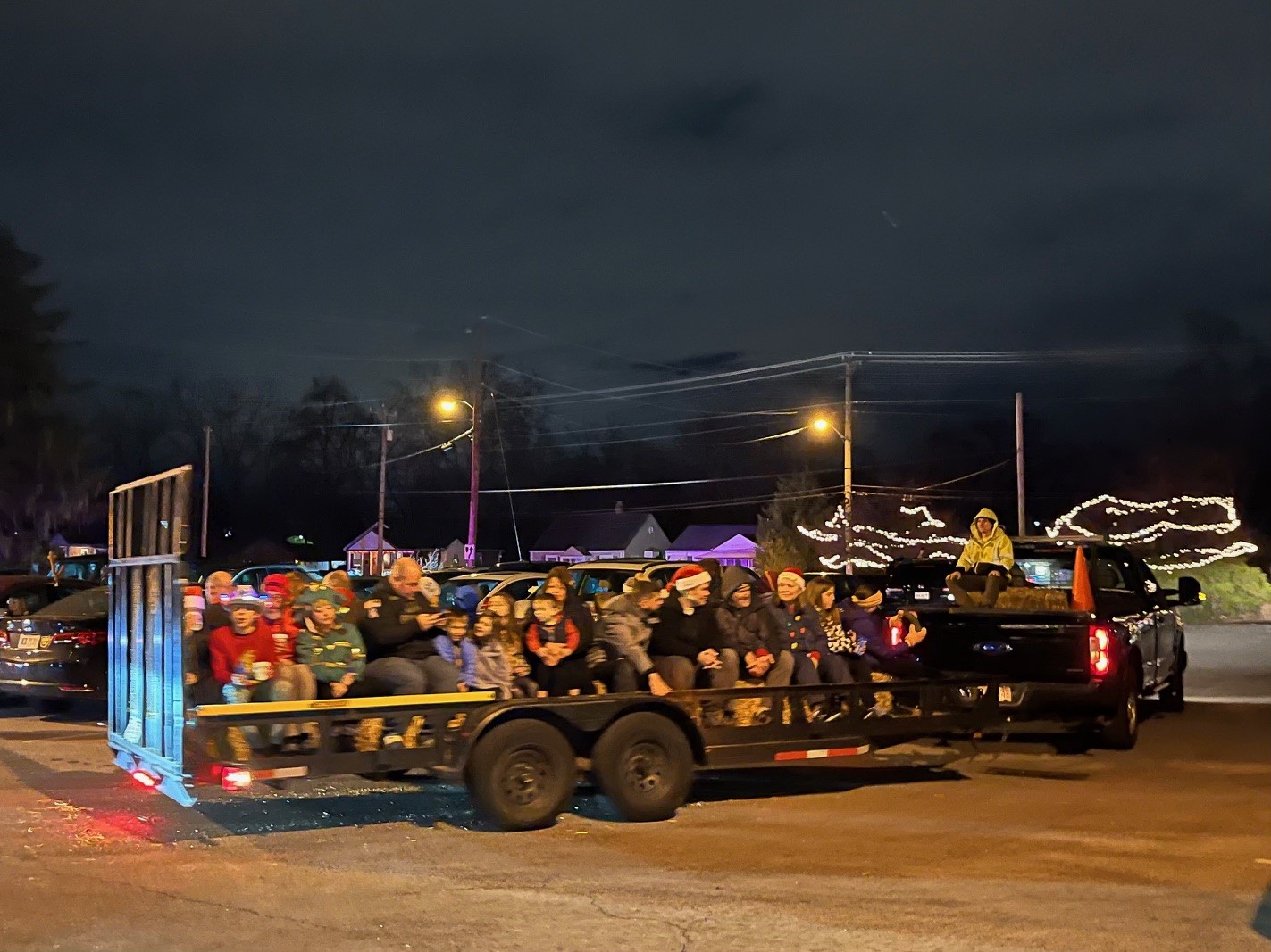 green pickup truck pulling hay ride filled with people