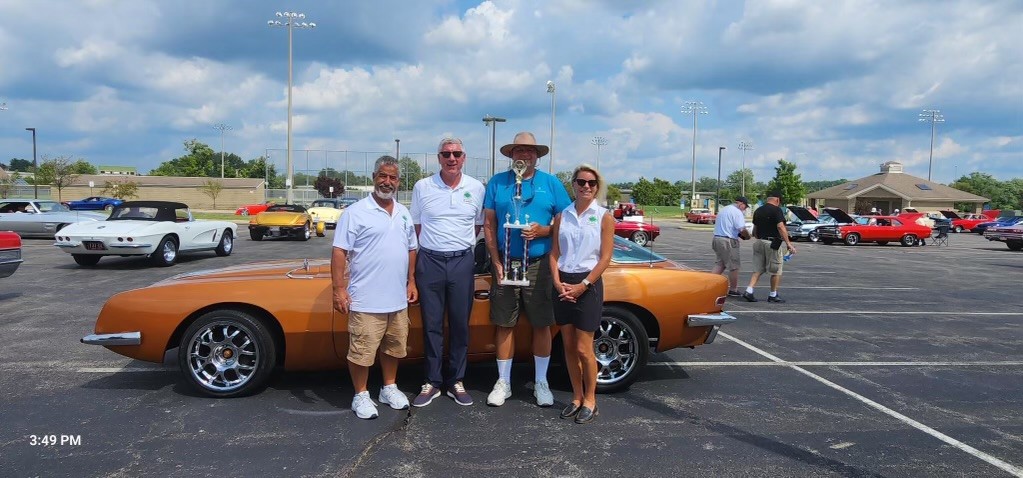 Trustees Tracy Kellums, Tom Weidman, and Tracy Schwegmann congratulate Best of Show winner Don Budke, shown here with his winning 1963 Studebaker.